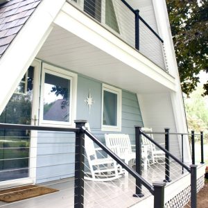Composite steps and deck with black railing on an A-frame cottage, West Michigan composite deck builders