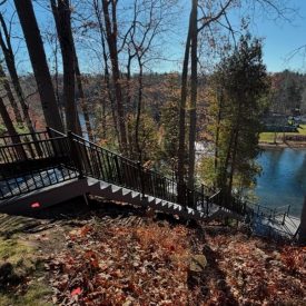 Black aluminum stairs descending a bluff to the lake in autumn, Lake Michigan aluminum stair builders