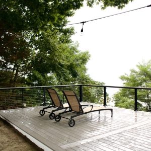 Composite deck with loungers and cable railing at a Lake Michigan home, composite deck builders