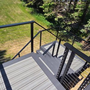 Composite stairs with black railing seen from the deck above, West Michigan composite stair builders