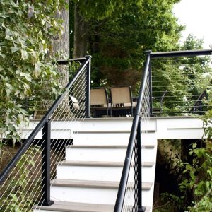 Composite stairs with cable railing in a wooded yard, West Michigan composite stair builders