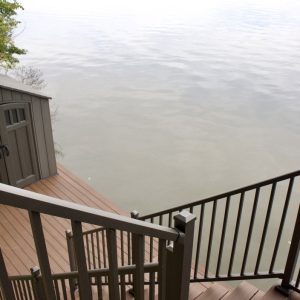 Composite stairs with black railing leading down to an inland lake, West Michigan composite stair builders