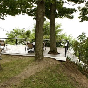Shaded composite deck under mature trees at a lakefront home, Lake Michigan composite deck builders