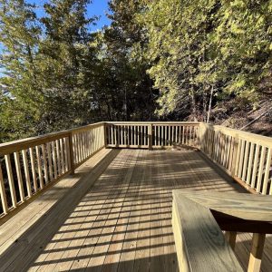 Wood deck with built-in bench in a wooded lakefront setting, West Michigan wood deck builders